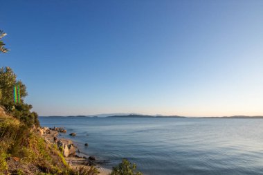 Zeytin ağaçlarıyla dolu bir tepeden gün batımına ve denize bak. Ouranoupoli, Selanik, Orta Makedonya ve Yunanistan sahillerindeki Akdeniz manzarasının akşam havası