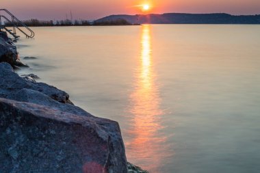 Yazın bir gölün kıyısında gün batımı. Horiont 'u geniş görüşlü, renkli bir gökyüzü. Balaton, Balaton Gölü, Sifok, Macaristan 'da doğa manzarası