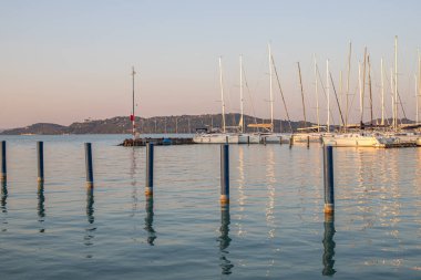 Yazın sahilde gün doğumu ve bir gölün limanı. Horiont 'u geniş görüşlü, renkli bir gökyüzü. Doğa manzarası Balatonfred Vitorlskikt, Balaton, Balaton Gölü, Sifok, Macaristan