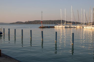 Yazın sahilde gün doğumu ve bir gölün limanı. Horiont 'u geniş görüşlü, renkli bir gökyüzü. Doğa manzarası Balatonfred Vitorlskikt, Balaton, Balaton Gölü, Sifok, Macaristan