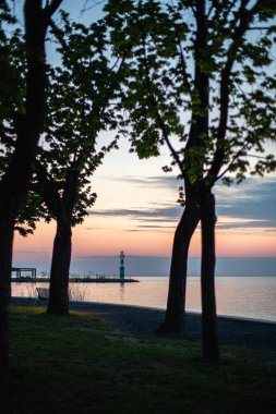 Yazın sahilde gün doğumu ve bir gölün limanı. Horiont 'u geniş görüşlü, renkli bir gökyüzü. Doğa manzarası Tihany marinası, Balaton, Balaton Gölü, Sifok, Macaristan