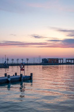 Yazın sahilde gün doğumu ve bir gölün limanı. Horiont 'u geniş görüşlü, renkli bir gökyüzü. Doğa manzarası Tihany marinası, Balaton, Balaton Gölü, Sifok, Macaristan