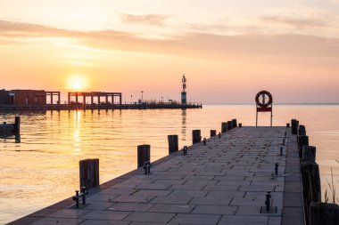 Yazın sahilde gün doğumu ve bir gölün limanı. Horiont 'u geniş görüşlü, renkli bir gökyüzü. Doğa manzarası Tihany marinası, Balaton, Balaton Gölü, Sifok, Macaristan