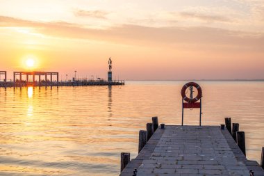 Yazın sahilde gün doğumu ve bir gölün limanı. Horiont 'u geniş görüşlü, renkli bir gökyüzü. Doğa manzarası Tihany marinası, Balaton, Balaton Gölü, Sifok, Macaristan