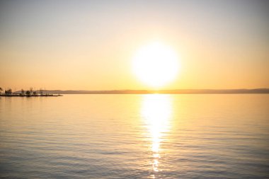 Yazın sahilde gün doğumu ve bir gölün limanı. Horiont 'u geniş görüşlü, renkli bir gökyüzü. Doğa manzarası Balatonfred Vitorlskikt, Balaton, Balaton Gölü, Sifok, Macaristan