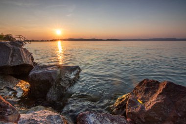 Yazın sahilde gün doğumu ve bir gölün limanı. Horiont 'u geniş görüşlü, renkli bir gökyüzü. Doğa manzarası Balatonfred Vitorlskikt, Balaton, Balaton Gölü, Sifok, Macaristan
