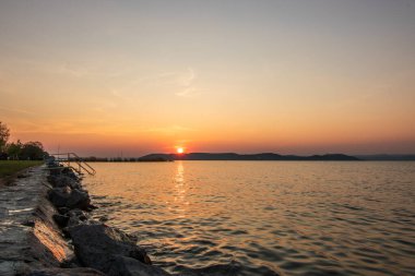 Yazın sahilde gün doğumu ve bir gölün limanı. Horiont 'u geniş görüşlü, renkli bir gökyüzü. Doğa manzarası Balatonfred Vitorlskikt, Balaton, Balaton Gölü, Sifok, Macaristan