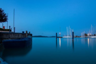 Yazın sahilde gün doğumu ve bir gölün limanı. Horiont 'u geniş görüşlü, renkli bir gökyüzü. Doğa manzarası Balatonfred Vitorlskikt, Balaton, Balaton Gölü, Sifok, Macaristan