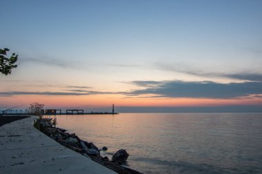 Yazın sahilde gün doğumu ve bir gölün limanı. Horiont 'u geniş görüşlü, renkli bir gökyüzü. Doğa manzarası Tihany marinası, Balaton, Balaton Gölü, Sifok, Macaristan