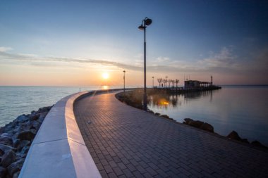 Yazın sahilde gün doğumu ve bir gölün limanı. Horiont 'u geniş görüşlü, renkli bir gökyüzü. Doğa manzarası Tihany marinası, Balaton, Balaton Gölü, Sifok, Macaristan