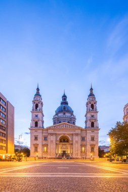 Old church, cathedral in a historic old town in Eastern Europe. Sunrise on an urban square in front of St. Stephen's Basilica in Budapest, Hungary clipart