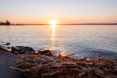 Yazın bir gölün kıyısında gün batımı. Horiont 'u geniş görüşlü, renkli bir gökyüzü. Balaton, Balaton Gölü, Sifok, Macaristan 'da doğa manzarası