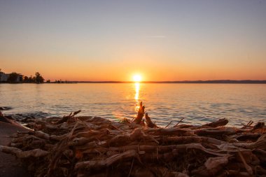 Sunset on the shore of a lake in summer. Colorful sky with a wide view of the Horiont. Nature landscape at Balaton, Lake Balaton, Sifok, Hungary clipart