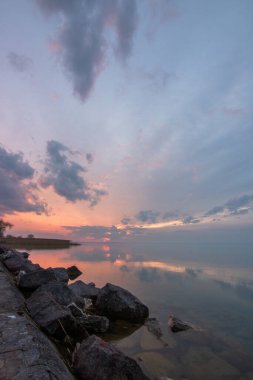 Sakin bir gölün kıyısından alınan su manzarası. Gün batımında ufka yansıyan suyun üzerinden bak. Siofok Limanı, Balaton, Macaristan