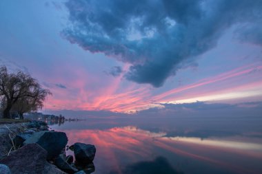 Sakin bir gölün kıyısından alınan su manzarası. Gün batımında ufka yansıyan suyun üzerinden bak. Siofok Limanı, Balaton, Macaristan