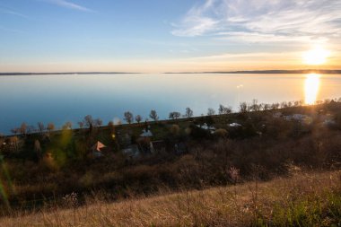 Akşamları bir gölün üzerindeki tepeden manzara. Doğada güzel bir manzara. Balatonakarattya, Balaton, Macaristan 'da romantik gün batımı