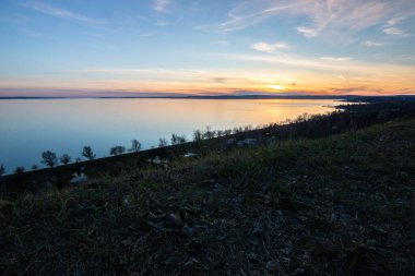 Akşamları bir gölün üzerindeki tepeden manzara. Doğada güzel bir manzara. Balatonakarattya, Balaton, Macaristan 'da romantik gün batımı