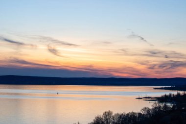 Akşamları bir gölün üzerindeki tepeden manzara. Doğada güzel bir manzara. Balatonakarattya, Balaton, Macaristan 'da romantik gün batımı