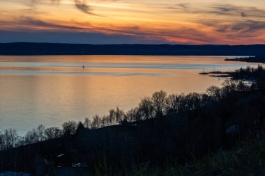 Akşamları bir gölün üzerindeki tepeden manzara. Doğada güzel bir manzara. Balatonakarattya, Balaton, Macaristan 'da romantik gün batımı