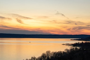 Akşamları bir gölün üzerindeki tepeden manzara. Doğada güzel bir manzara. Balatonakarattya, Balaton, Macaristan 'da romantik gün batımı