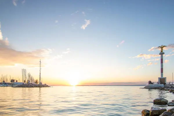 stock image Fantastic sunset on a large lake. Standing on the shore looking to the horizon across the lake into the sun. Romantic landscape shot at Lake Balaton, Hungary