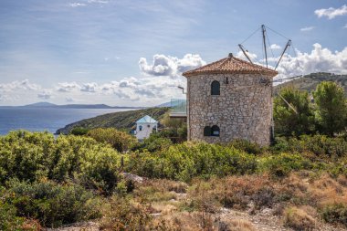 Akşamları tipik Yunan yel değirmeni. Yunanistan 'ın Akdeniz mimari tarzında. Akdeniz 'de bir uçurumun kenarında duruyor. Potamitis Yel Değirmeni, İyon Adaları, Yunanistan