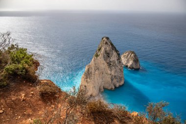 Akdeniz yeteneğine sahip sahil manzaralı bir manzaraya sahip bir bakış açısı. Sabah güneşinde deniz üzerinde sisli ve güneşli bir şekilde çekildi. Myzithres Kayası, İyon Adası Zakynthos, Yunanistan
