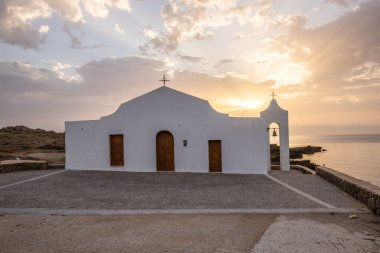 Deniz kenarındaki küçük Yunan kilisesi, gün doğumu veya gün batımı. Zakyntos adasından manzara fotoğrafı. Deniz manzarası güzelmiş.