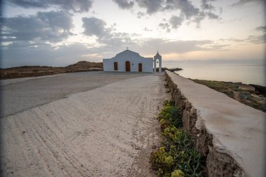 Deniz kenarındaki küçük Yunan kilisesi, gün doğumu veya gün batımı. Zakyntos adasından manzara fotoğrafı. Deniz manzarası güzelmiş.