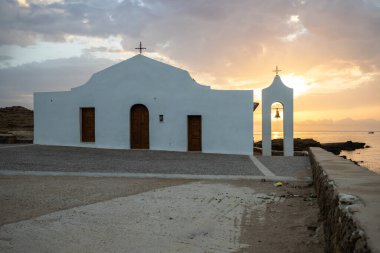 Deniz kenarındaki küçük Yunan kilisesi, gün doğumu veya gün batımı. Zakyntos adasından manzara fotoğrafı. Deniz manzarası güzelmiş.
