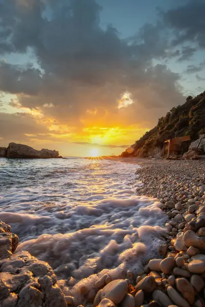 Gün doğumunda gizli körfez. Küçük kuma, çakıl taşına, sıcak renklerde plaja ve sabah ışığına baktım. Xigia Sülfür Plajları 'ndaki deniz manzarası, İyon Adaları, Yunanistan