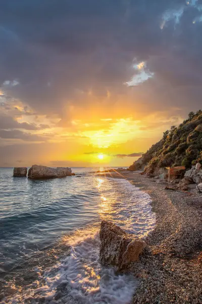 Gün doğumunda gizli körfez. Küçük kuma, çakıl taşına, sıcak renklerde plaja ve sabah ışığına baktım. Xigia Sülfür Plajları 'ndaki deniz manzarası, İyon Adaları, Yunanistan