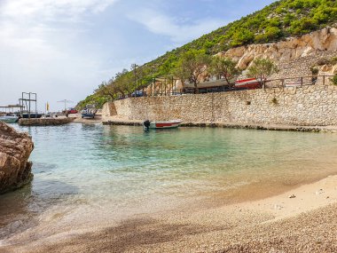 Kumsaldaki bulutlar. Denizi ve kumu seyret. Rüzgâr sörfçüleri suda. Sörfçüler için harika bir hava, Lagana Sahili, İyon Adası Zakynthos, Yunanistan 'da sahile gidenler için kötü hava