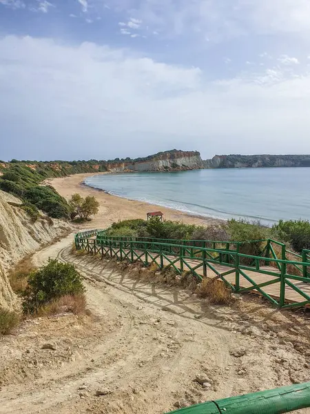 Kumsaldaki bulutlar. Denizi ve kumu seyret. Rüzgâr sörfçüleri suda. Sörfçüler için harika bir hava, Lagana Sahili, İyon Adası Zakynthos, Yunanistan 'da sahile gidenler için kötü hava