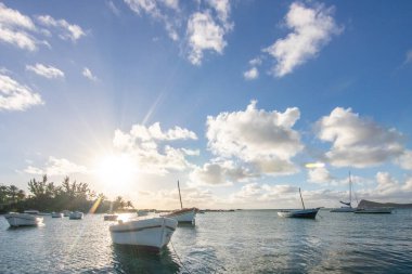 Balıkçı tekneleri olan küçük bir liman manzaralı bir manzara. Mauritius, Malheureux Burnu 'nda günbatımı manzaralı tropikal bir manzara.