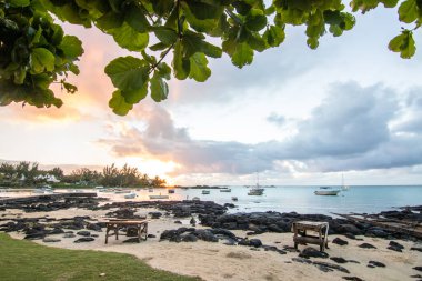 Balıkçı tekneleri olan küçük bir liman manzaralı bir manzara. Mauritius, Malheureux Burnu 'nda günbatımı manzaralı tropikal bir manzara.