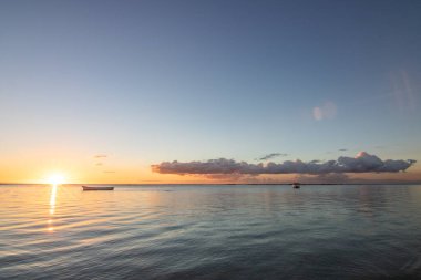 Gün batımında Hint Okyanusu manzaralı güzel kumlu bir plajda gün batımı. Flic en Flac plajında deniz ve tropikal manzara, Mauritius, Afrika