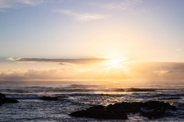 Işık dalgalarıyla denizin üzerinde gün doğumu. Lav taşlı kum kumsalı ve mavi suyla alternatif mavi su. Hint Okyanusu 'nda bir ada, beklenmedik bir plaj, Trou dEau Douce, Mauritius, Afrika