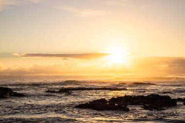 Işık dalgalarıyla denizin üzerinde gün doğumu. Lav taşlı kum kumsalı ve mavi suyla alternatif mavi su. Hint Okyanusu 'nda bir ada, beklenmedik bir plaj, Trou dEau Douce, Mauritius, Afrika