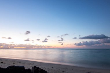 Sabahları kumlu harika bir sahil. Hint Okyanusu 'nda bir ada, deniz manzaralı fotoğraf ya da deniz manzaralı deniz manzaralı. Sahilde küçük lav kayaları var Trou d 'Eau Douce, Mauritius
