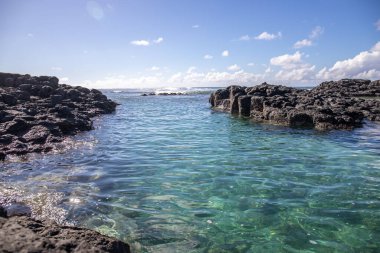 Gündüzleri güzel bir sahil. Lav taşları, beyaz kumlu plajlarla yer değiştiriyor. Hint Okyanusu 'ndaki bir adanın kıyı manzarası, birden bire, Trou dEau Douce, Mauritius, Afrika