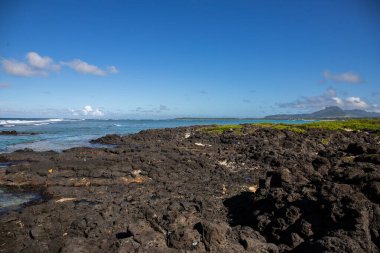 Gündüzleri güzel bir sahil. Lav taşları, beyaz kumlu plajlarla yer değiştiriyor. Hint Okyanusu 'ndaki bir adanın kıyı manzarası, birden bire, Trou dEau Douce, Mauritius, Afrika