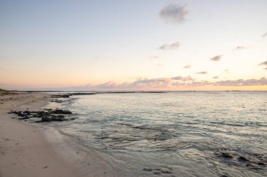 Sabahları kumlu harika bir sahil. Hint Okyanusu 'nda bir ada, deniz manzaralı fotoğraf ya da deniz manzaralı deniz manzaralı. Sahilde küçük lav kayaları var Trou d 'Eau Douce, Mauritius