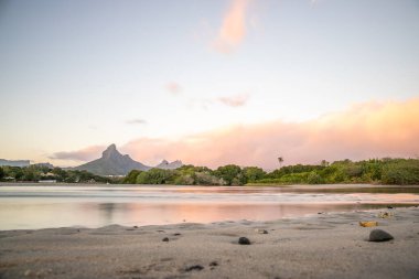 Nehirde bir körfez. Bir tatil adasında pastel renkli günbatımında rüya kumsalı. Mauritius adasındaki sığ plaj, Tamarin.