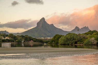 Nehirde bir körfez. Bir tatil adasında pastel renkli günbatımında rüya kumsalı. Mauritius adasındaki sığ plaj, Tamarin.