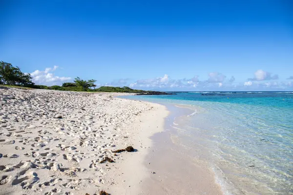 Sabahları kumlu harika bir sahil. Hint Okyanusu 'nda bir ada, deniz manzaralı fotoğraf ya da deniz manzaralı deniz manzaralı. Sahilde küçük lav kayaları var Trou d 'Eau Douce, Mauritius