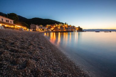 Akdeniz 'deki güzel bir köyün tarihi ufuk çizgisi, sabah kumsalda ve denizde gün doğumunda çekildi. Moenika Draga, Moscenicka Draga, Istria, Hırvatistan 'da rüya limanı manzarası