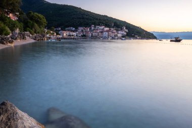 Akdeniz 'deki güzel bir köyün tarihi ufuk çizgisi, sabah kumsalda ve denizde gün doğumunda çekildi. Moenika Draga, Moscenicka Draga, Istria, Hırvatistan 'da rüya limanı manzarası