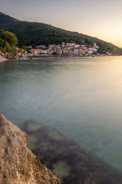 Akdeniz 'deki güzel bir köyün tarihi ufuk çizgisi, sabah kumsalda ve denizde gün doğumunda çekildi. Moenika Draga, Moscenicka Draga, Istria, Hırvatistan 'da rüya limanı manzarası