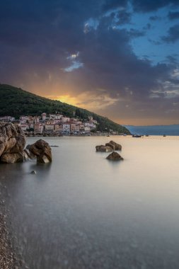 Akdeniz 'deki güzel bir köyün tarihi ufuk çizgisi, sabah kumsalda ve denizde gün doğumunda çekildi. Moenika Draga, Moscenicka Draga, Istria, Hırvatistan 'da rüya limanı manzarası